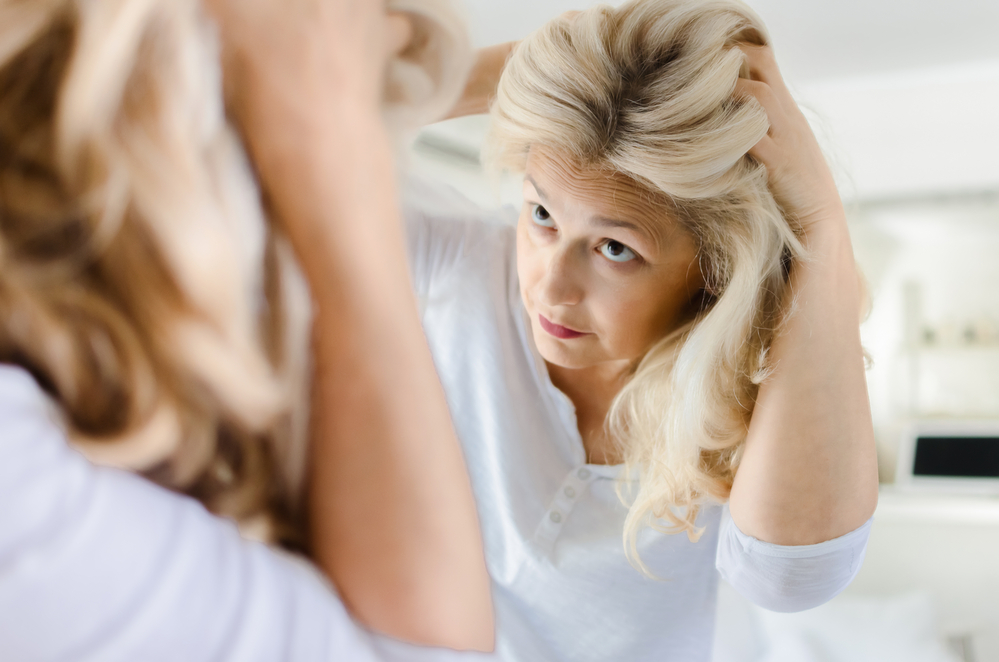 Woman looking at mirror her hair